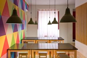蓬塔德尔加达Azorean Urban Lodge的一间设有桌子和多彩墙壁的用餐室