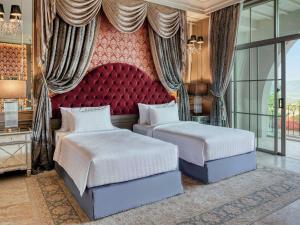 Ban Wang SaiMövenpick Resort Khao Yai的一间卧室设有两张床和红色床头板