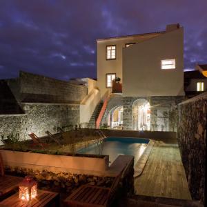 蓬塔德尔加达Azorean Urban Lodge的夜间带游泳池的别墅