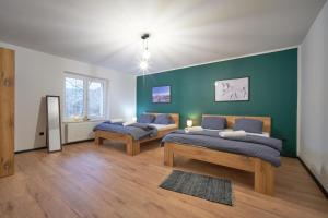 利波瓦拉尼Apartmány U Rodinky的一间卧室设有两张床和绿色的墙壁