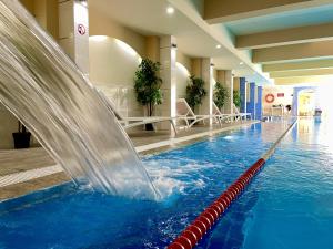 桑丹斯基AquaSun Family Hotel的一座大楼内带水滑梯的游泳池