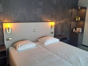 霍斯特霍斯特 - 芬洛公园酒店的卧室配有白色的床和2个枕头