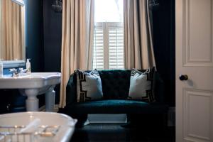 切尔滕纳姆三十八号公园住宿加早餐旅馆的一间带绿色椅子和水槽的浴室