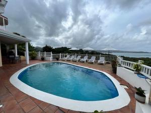 Bois dʼOrangeStunning 4-Bed Villa in Gros Islet St Lucia的一个带椅子的庭院和大海上的游泳池