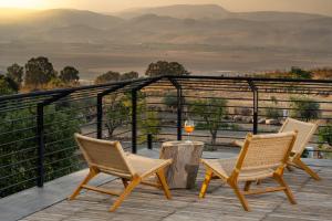 GadotPereh Mountain Resort的观景甲板上配有两把椅子和一张桌子