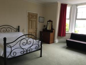 米尔顿凯恩斯Furtho Manor Farm的一间卧室配有一张床、一张沙发和一个窗口