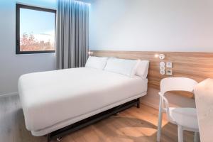 奥埃拉斯B&B HOTEL Lisboa Oeiras的卧室配有白色的床和桌子