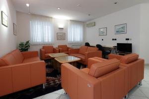 里耶卡Rijeka Budget Rooms的一间配备有橙色椅子和平面电视的等候室