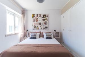 卡帕里卡海岸里斯本冲浪住宿加早餐旅馆的白色卧室配有一张带两个枕头的大床