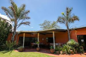 纳库鲁Punda Milias Lodge的前面有棕榈树的房子