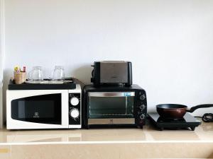 高兰Phumin Apartment的台面上配有微波炉和烤面包机
