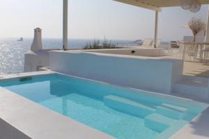 帕罗斯岛Thea Villas Paros, Villa Turquoise, private pool的一座位于大海背景的房子中的游泳池