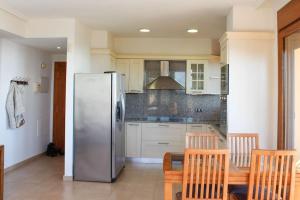 阿尔考斯布里Apartamento Alcocebre Beach Resort的厨房配有冰箱和桌椅