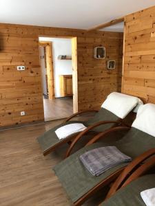 措布伦Glätzle`s Ferienhaus的客房铺有木地板,设有木质墙壁和椅子。