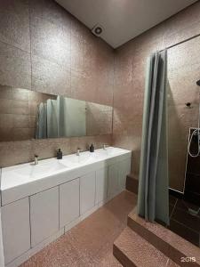 阿斯塔纳Flats Hostel的一间带两个盥洗盆和大镜子的浴室