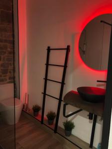 那慕尔Namur à Mur的浴室设有红色照明的镜子和水槽