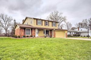 南菲尔德Suburban Detroit Home with Porch, Yard and Fire Pit!的前面有草坪的黄色房子