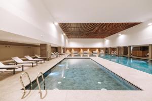 布勒伊-切尔维尼亚Valtur Cristallo Ski Resort, Dependance Cristallino的酒店的大型游泳池配有椅子