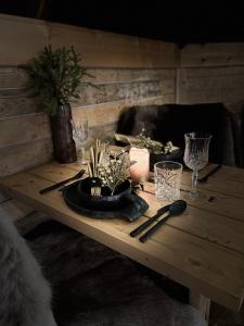 罗瓦涅米Skyfire Village Igloos的一张带玻璃杯的木桌和盘子