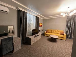 塞米伊Rooms Hotel Semey的客厅配有黄色沙发和电视