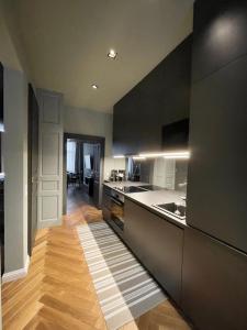 维也纳New Luxury Apartment Vienna的厨房配有黑色橱柜和木地板