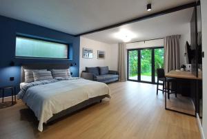 斯蒂格纳Apartamenty Między Mostami的一间卧室设有蓝色的墙壁、一张床和一张书桌