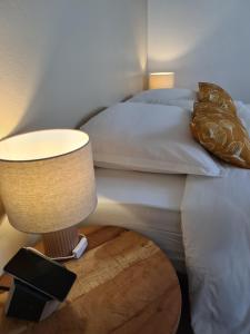 勒马兰La Villa Baie du Marin的一间卧室配有一张床和一张桌子上的台灯