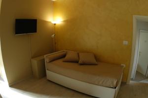 拉奎拉Dimora Offidius的一间小卧室,配有一张床和一台墙上的电视