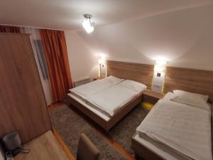 兹拉蒂博尔Vila Novaković X的酒店客房设有两张床和两盏灯。