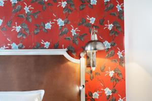 巴黎Le Robinet d'Or的一间卧室设有红色墙壁,配有花卉壁纸