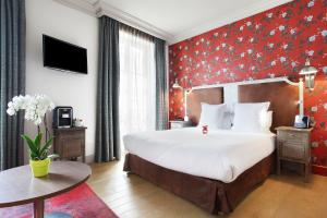 巴黎Le Robinet d'Or的一间卧室设有一张大床和红色的墙壁