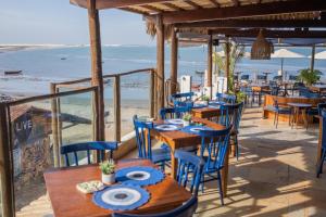杰里科科拉Vila Maria Pousada的海滩上带桌椅的餐厅