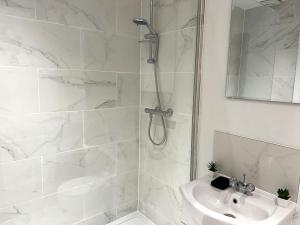 北安普敦New Two Bedroom Premium Apartment - Skylight - Northampton Town Centre的带淋浴和盥洗盆的白色浴室