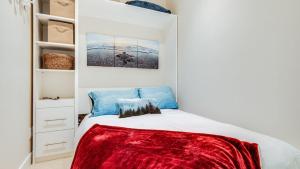维多利亚City Side Near Cook Street Village的一间卧室配有一张床铺,床上铺有红色毯子