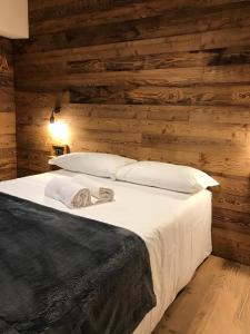 萨奥兹-杜尔克斯4Seasons appartamenti的卧室设有木墙和一张带白色枕头的床。