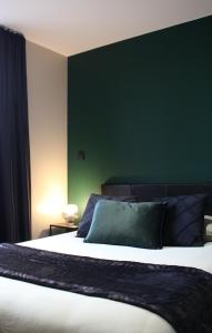 莫伯日Résidence "Le Vélodrome"的一间卧室设有一张大床和绿色的墙壁