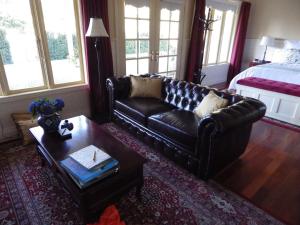 AshbourneThe Retreat at Amryhouse的客厅配有真皮沙发和茶几
