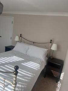 约维尔Two-bedroom Apartment的一间卧室配有一张带白色床单和两盏灯的床。
