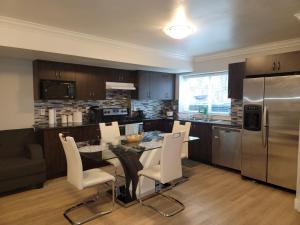 阿伯茨福德Oscar INN & 2bd Family Suite or Private Room的厨房配有桌椅和冰箱。