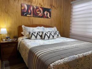 富塔莱乌富Cabaña el Arrayan Futaleufú的一间卧室配有一张带木制床头板的床