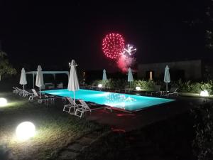 Bagnolo del SalentoTenuta Pigliano Hotel的夜间在泳池上空放烟花