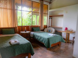 Quince MilWandari Lodge的客房设有两张床和窗户。