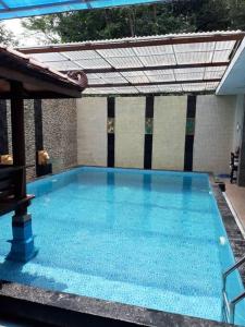 SalakanTITE homestay. Staycation feels @home的一个带屋顶的大型蓝色游泳池