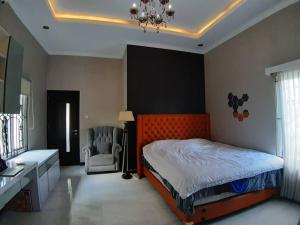 SalakanTITE homestay. Staycation feels @home的一间卧室配有橙色的床和椅子