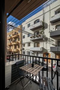 姆西达Luxury Msida Circle Suites的一个带木桌和椅子的阳台和一座建筑