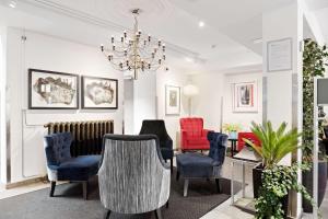 隆德隆德北欧贝斯特维斯特优质酒店的客厅配有椅子、桌子和吊灯。
