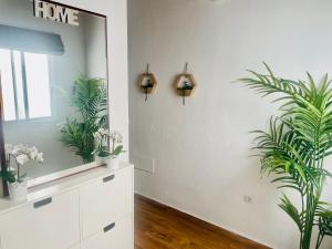 拉拉古纳Dakota’s house的浴室墙上挂有镜子和植物