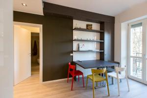 米兰梅勒佐公寓的一间用餐室,配有黑色的墙壁和色彩缤纷的椅子
