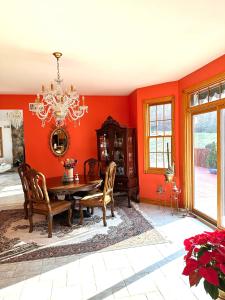 门罗Villa Verde B&B, bsm, Greenwood Lake, NY的一间拥有红色墙壁和桌椅的用餐室