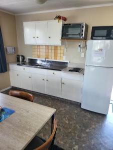 莱文Totara Lodge Motel的厨房配有白色橱柜和白色冰箱。